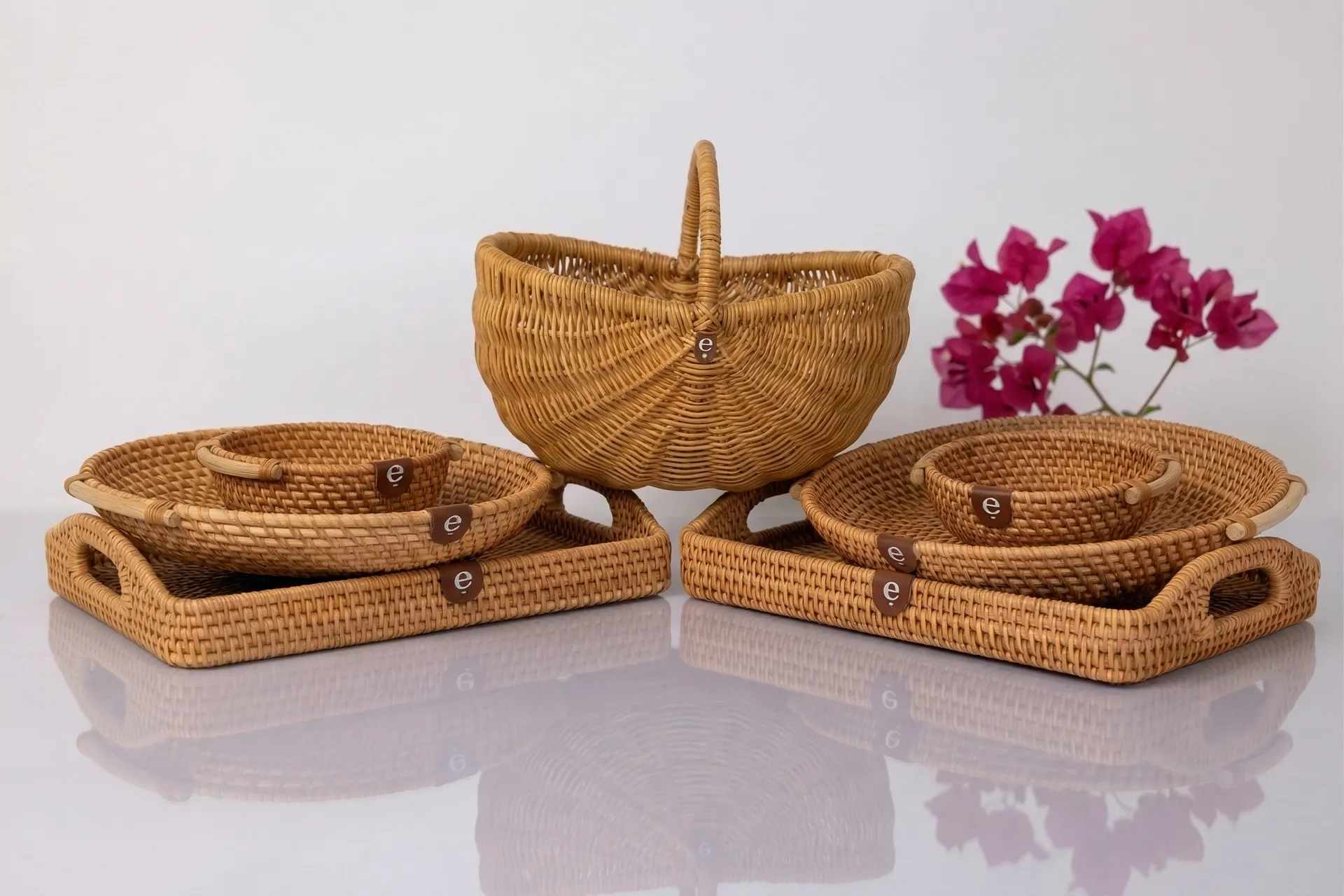 Set of woven baskets on a reflective surface with a white background
